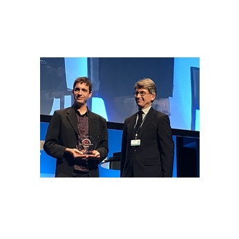 Photo du lauréat sur scène avec son prix