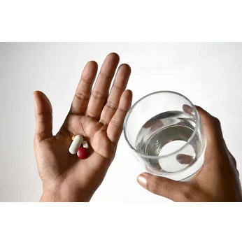 Photo d'une personne prenant un médicament sous forme de pilule