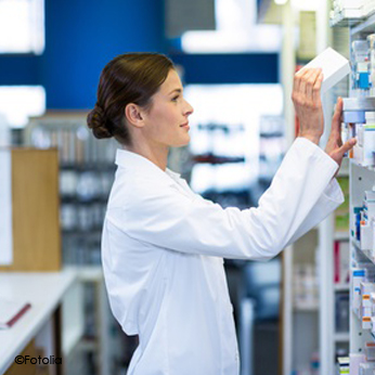 Photo d'une pharmacienne d'officine rangeant une boîte de médicament