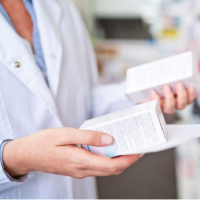 main d'un pharmacien tenant un médicament